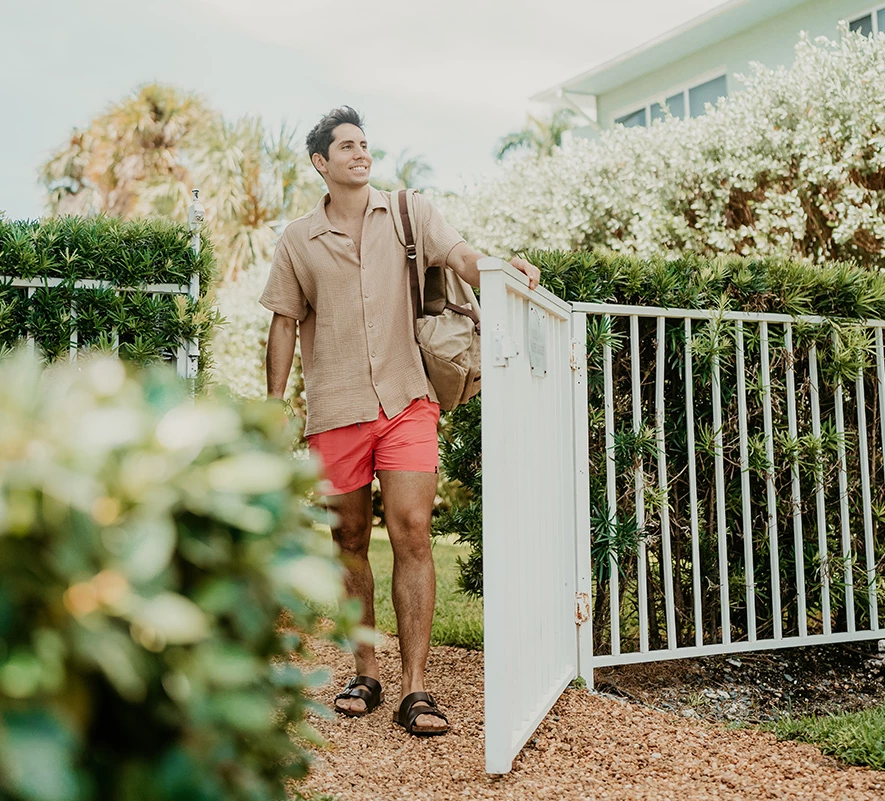 a man in shorts and a backpack walking through a gate