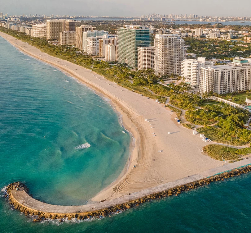 a beach with buildings and a body of water