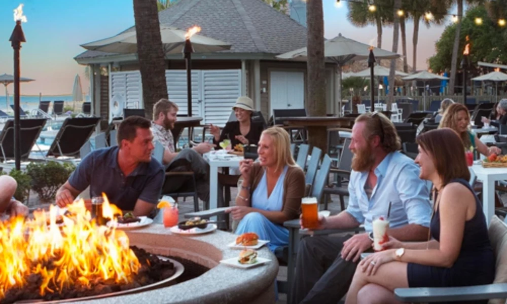 a group of people sitting around a fire pit