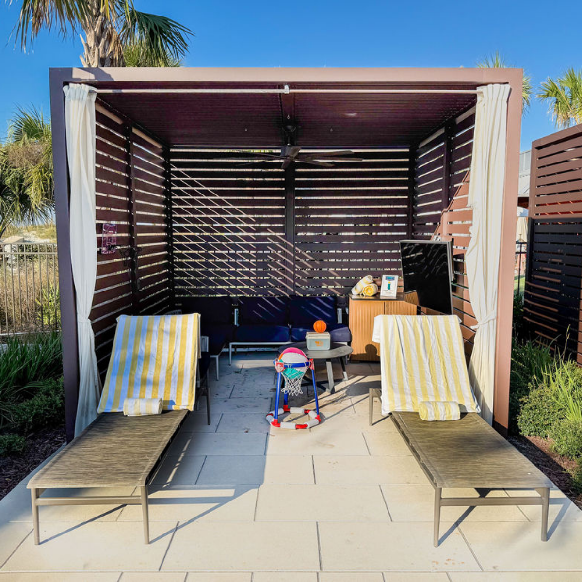 a lounge chairs and a table in a shade