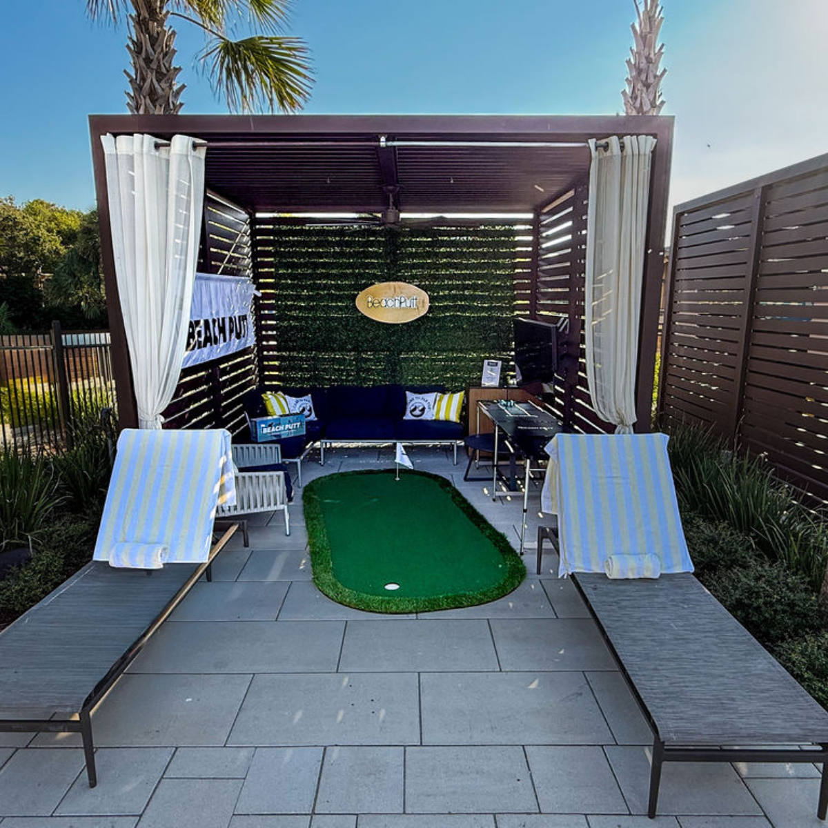 a covered area with lounge chairs and a golf course