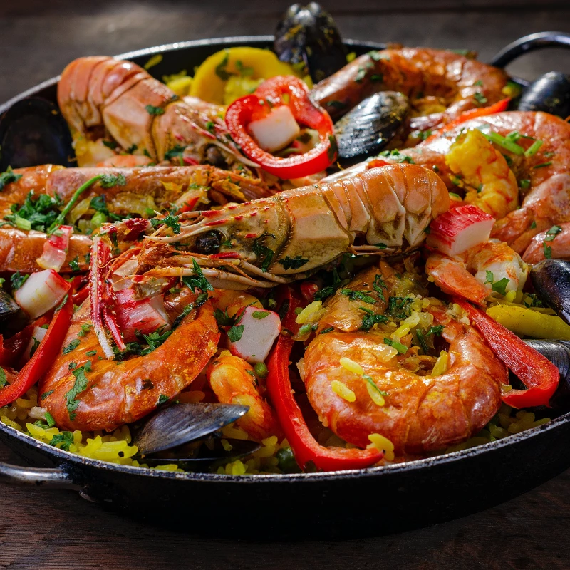 a pan of seafood with rice and shrimp