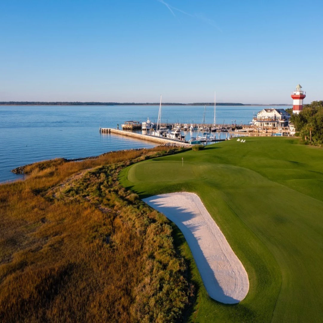 a golf course with a lighthouse and a dock