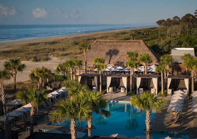 a pool with palm trees and a beach