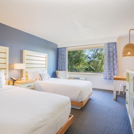 a room with two beds and a desk