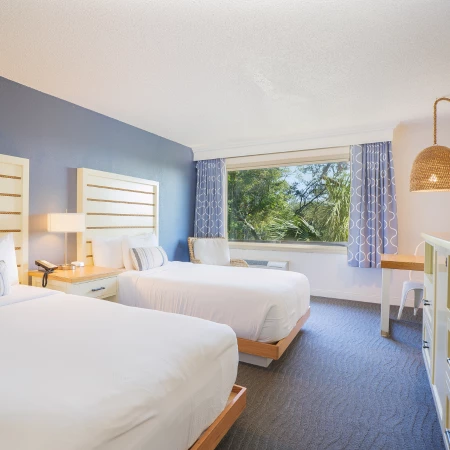 a room with two beds and a desk