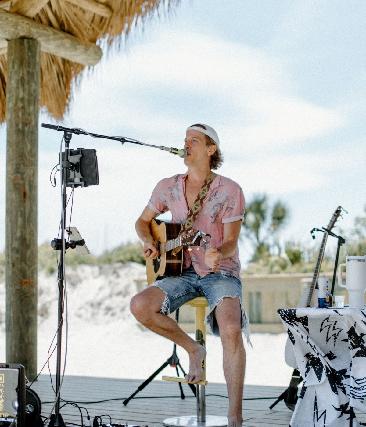 a man playing a guitar and singing into a microphone
