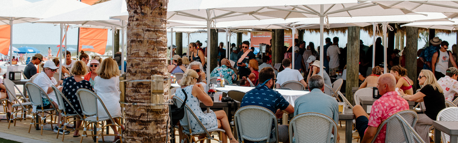 a group of people sitting at tables outside