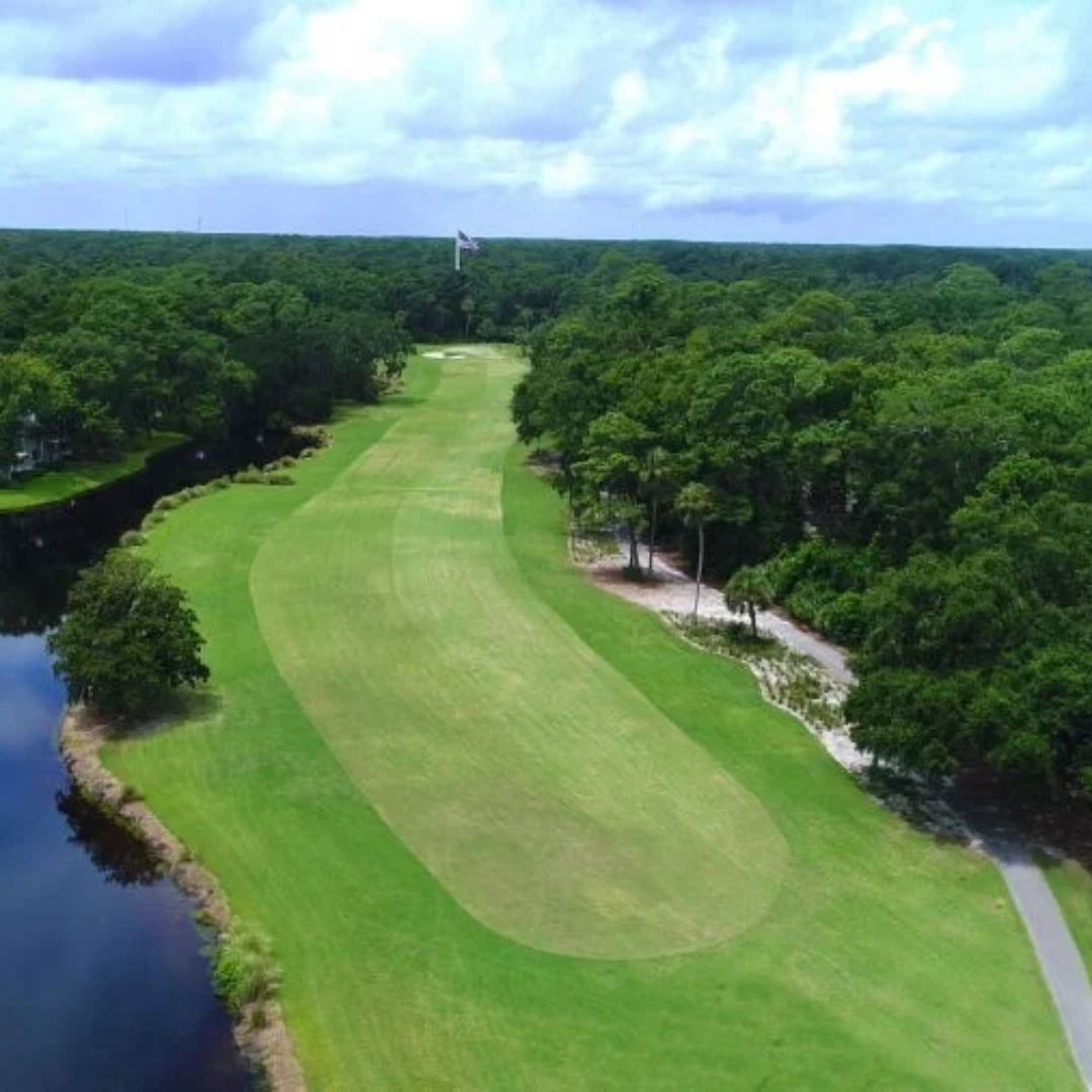 a golf course with a river and trees
