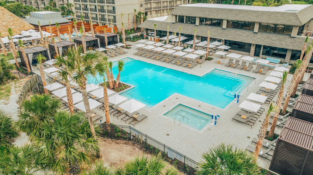 a swimming pool with lounge chairs and palm trees