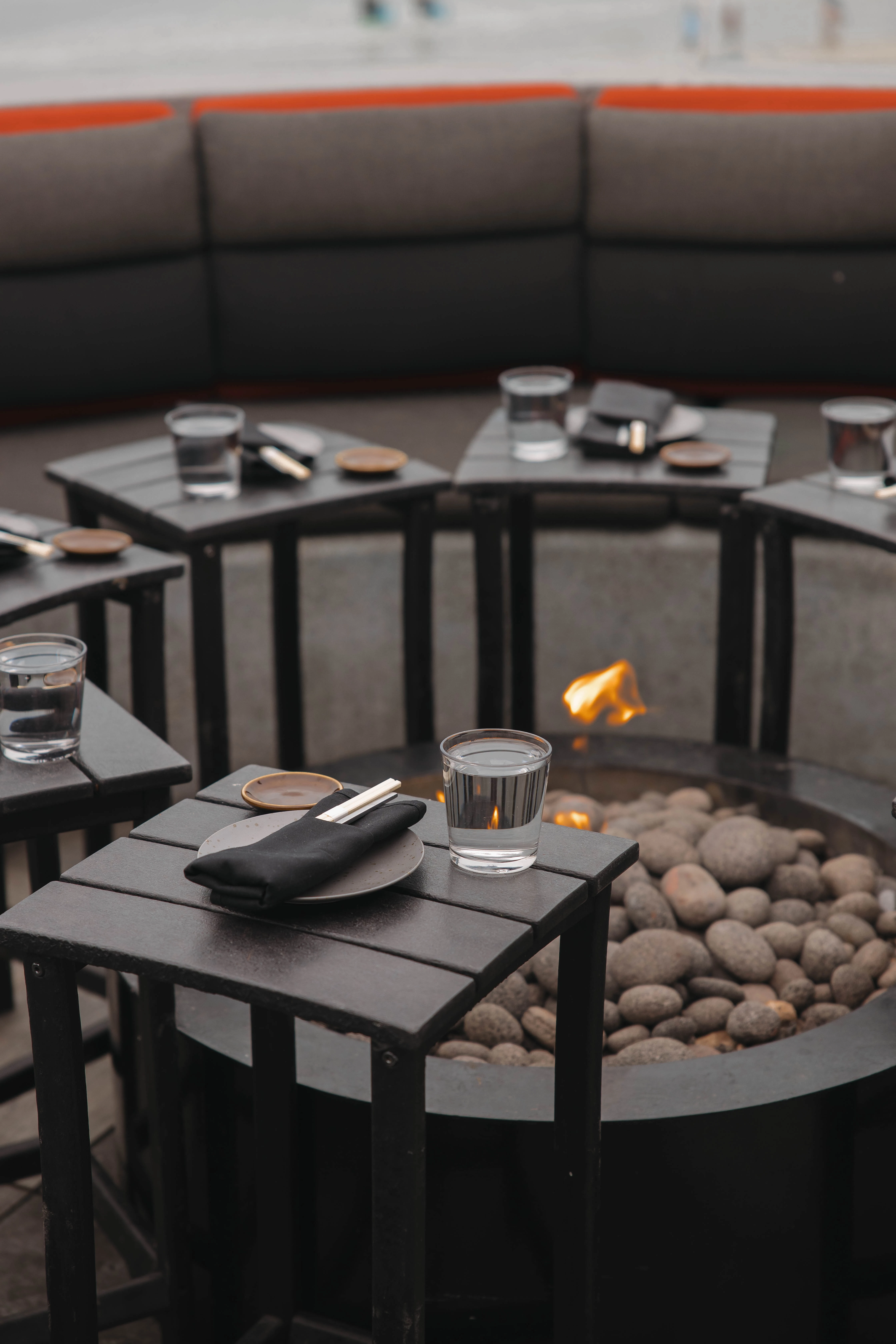 a table with plates and chopsticks on it and a fire pit