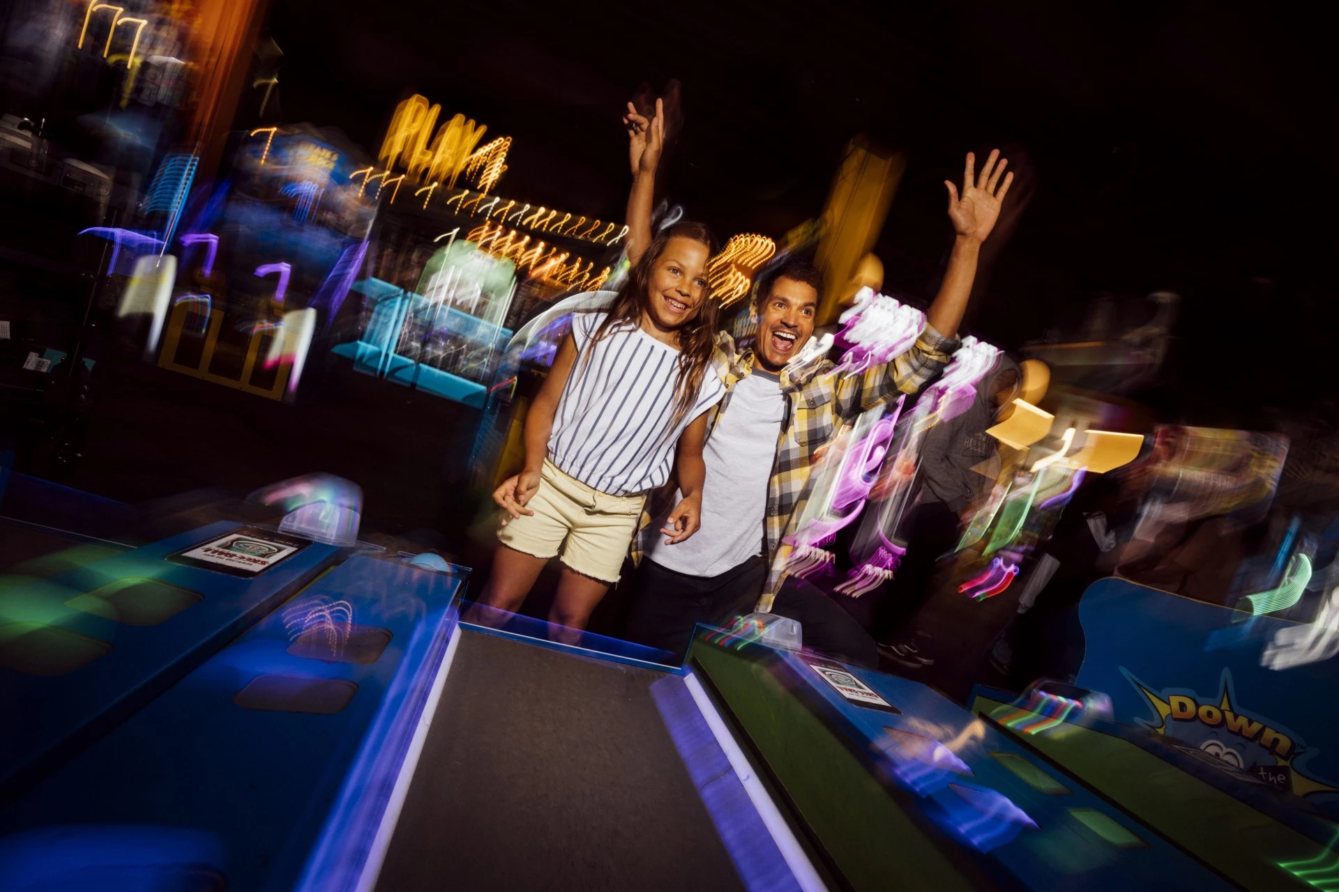 a man and a girl standing in a bowling alley