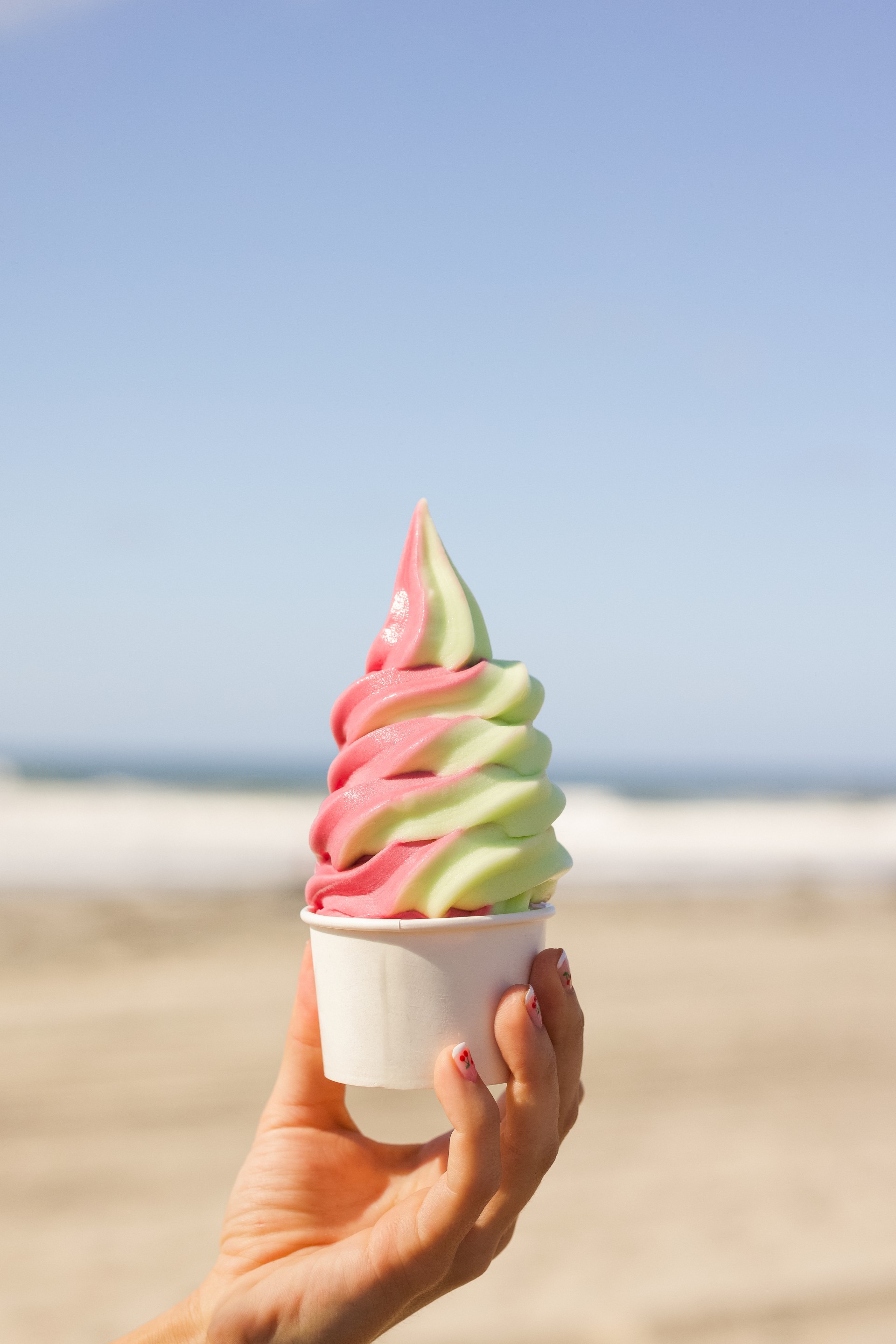 a hand holding a cup of ice cream