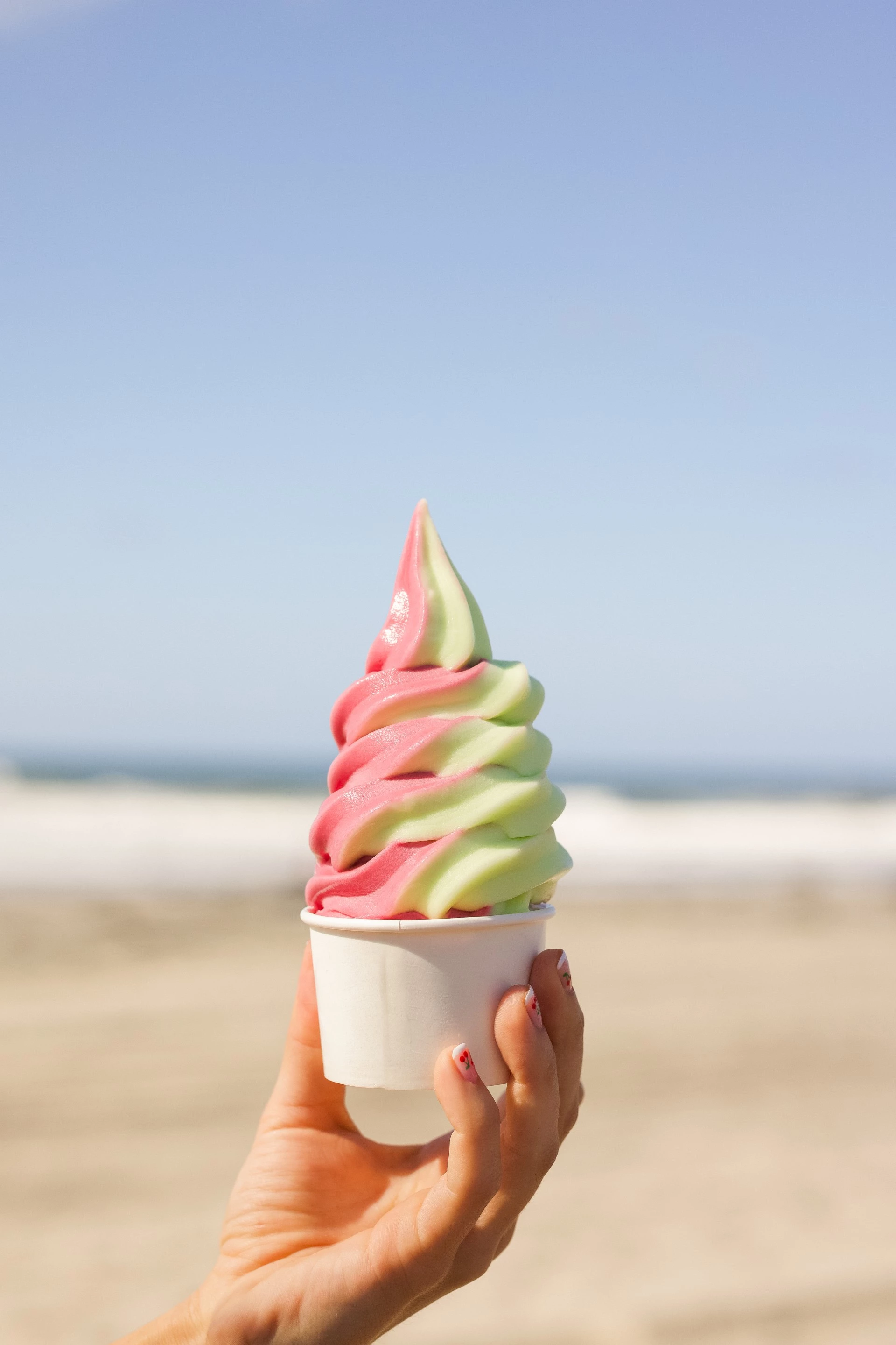 a hand holding a cup of ice cream