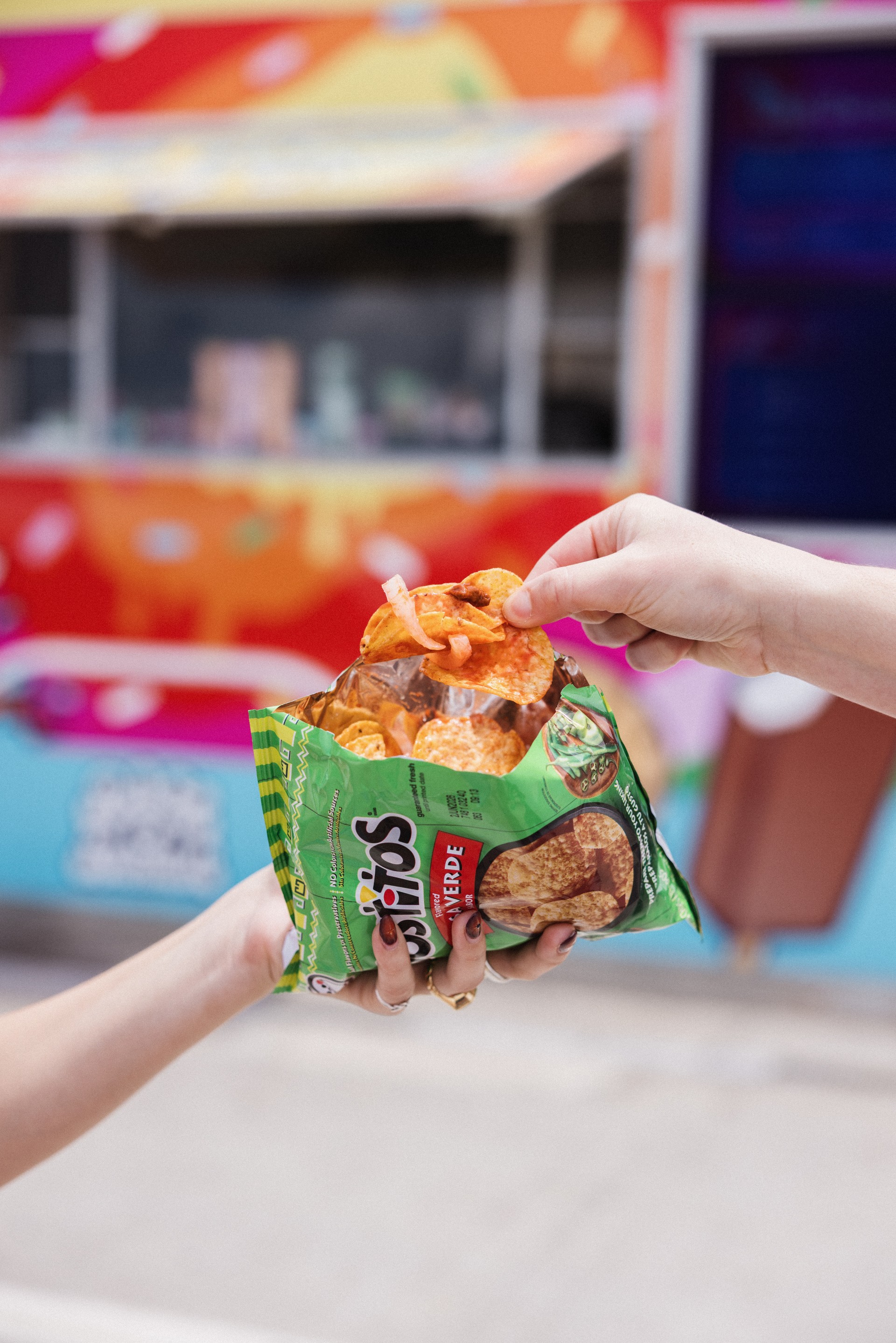 a hand holding a bag of chips called tostilocos