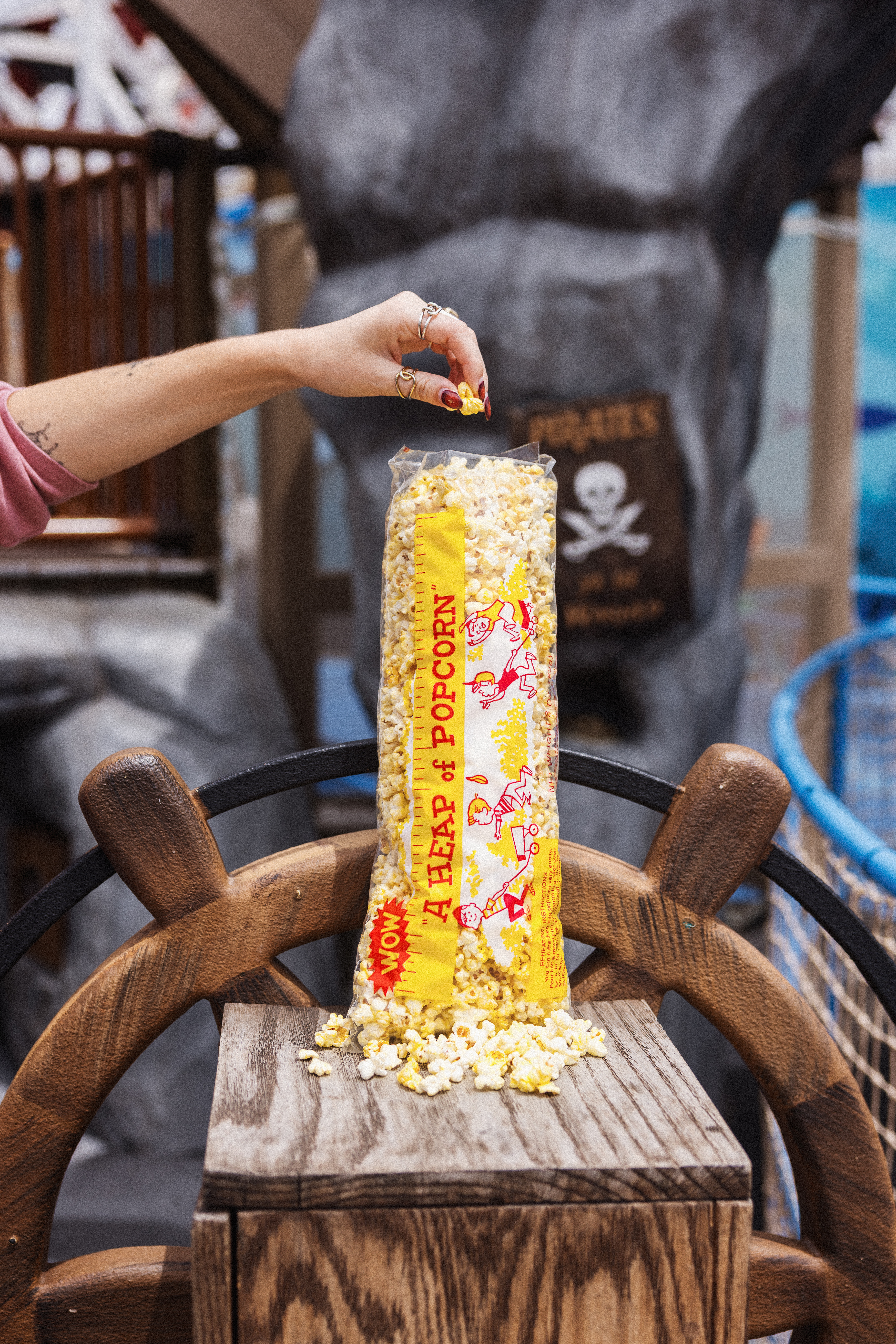a hand holding a bag of popcorn