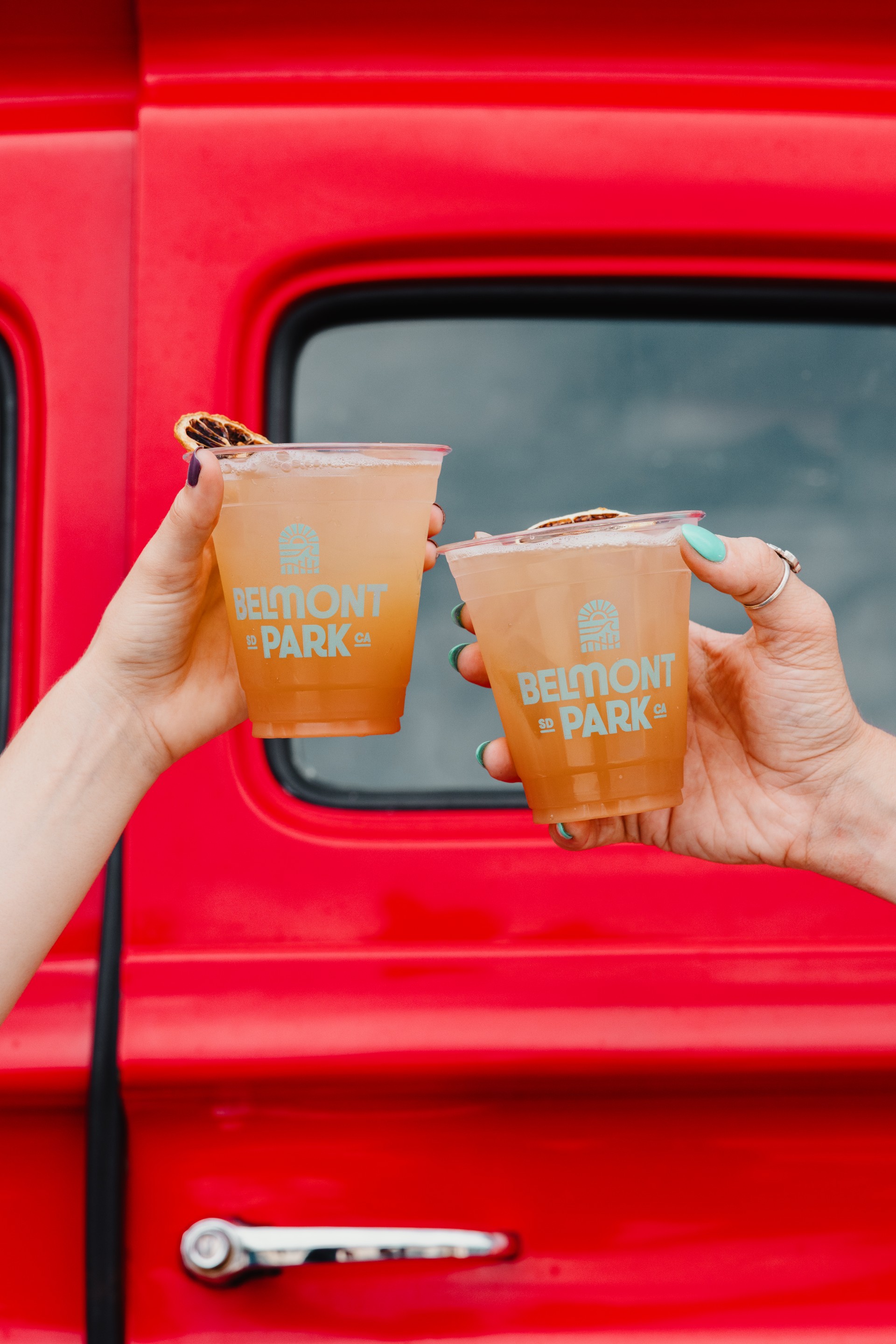 a pair of hands holding cups of drinks