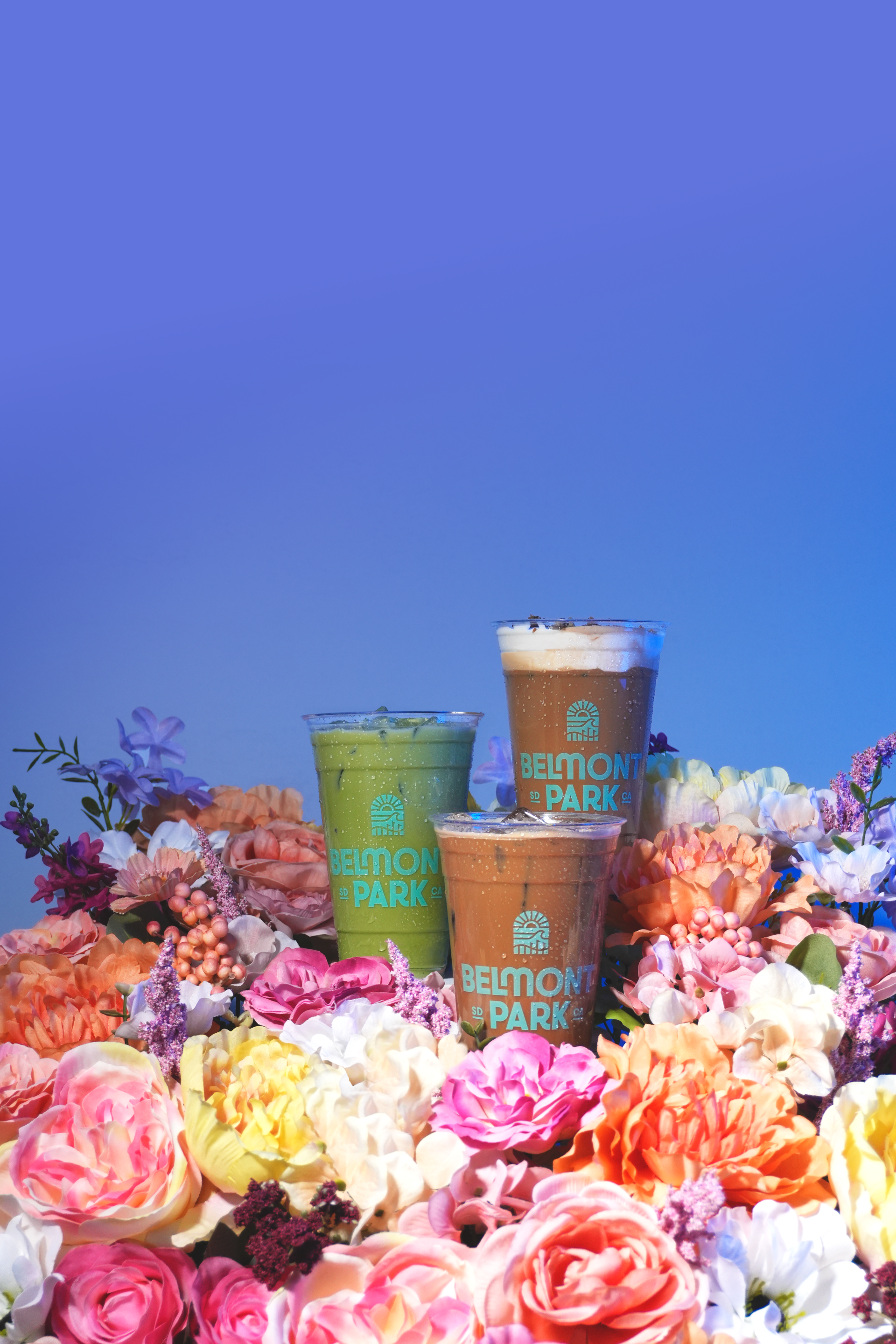 a group of drinks in plastic cups surrounded by flowers