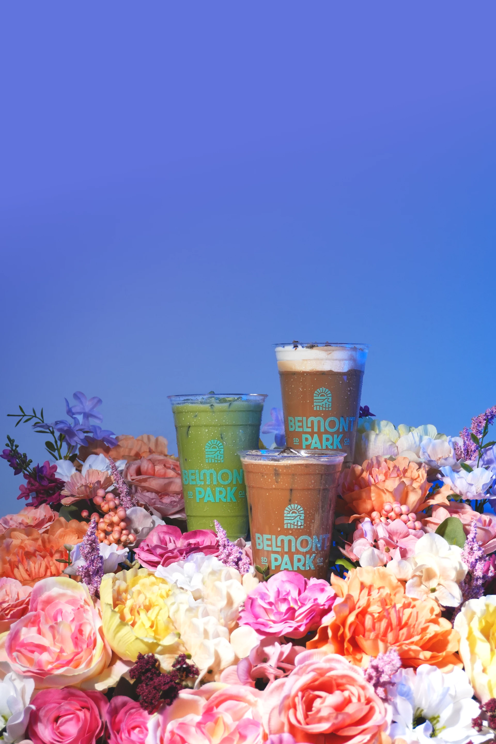 a group of drinks in plastic cups surrounded by flowers