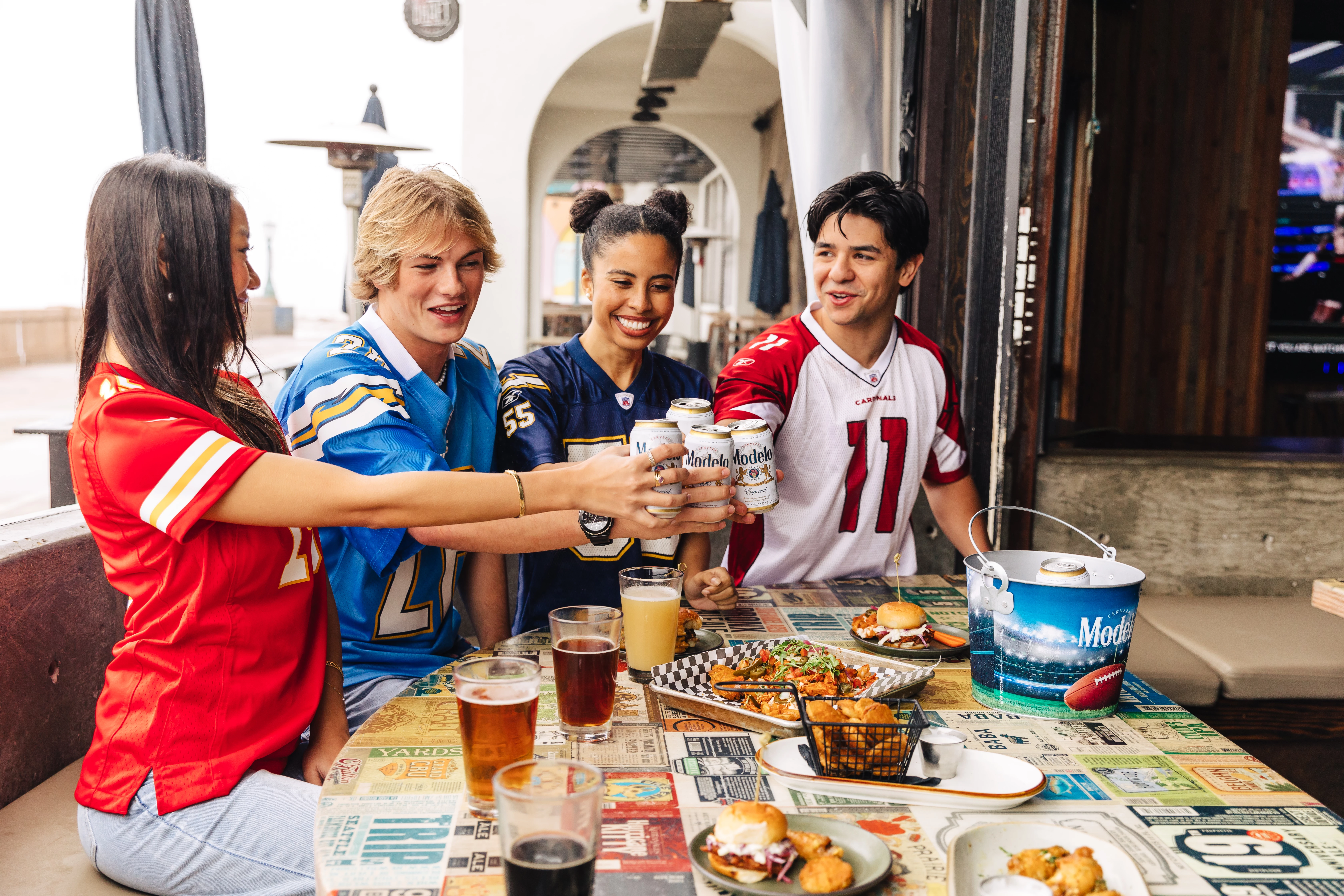 a group of people sitting around a table with food and drinks