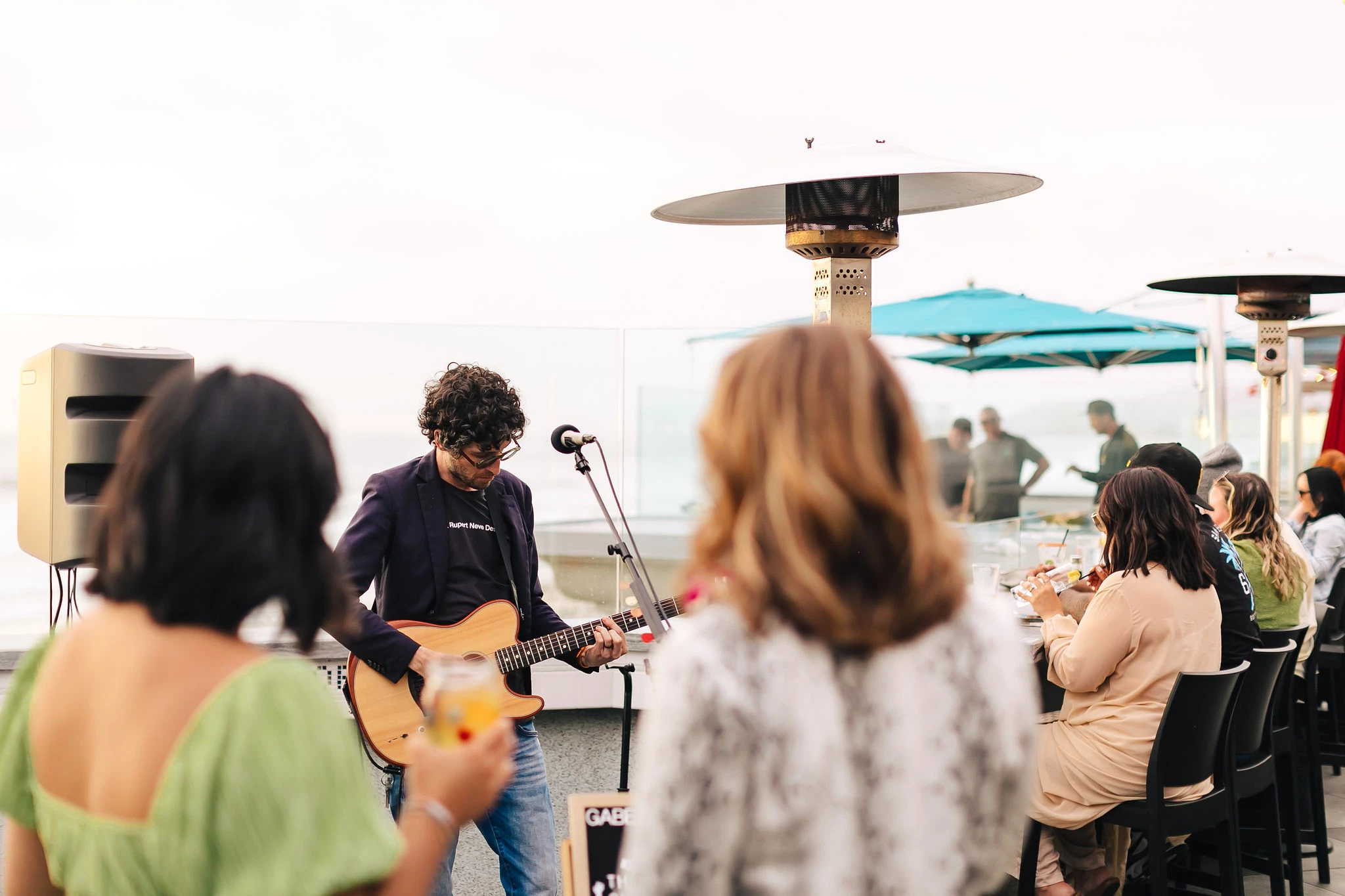 a man playing guitar and singing with people around