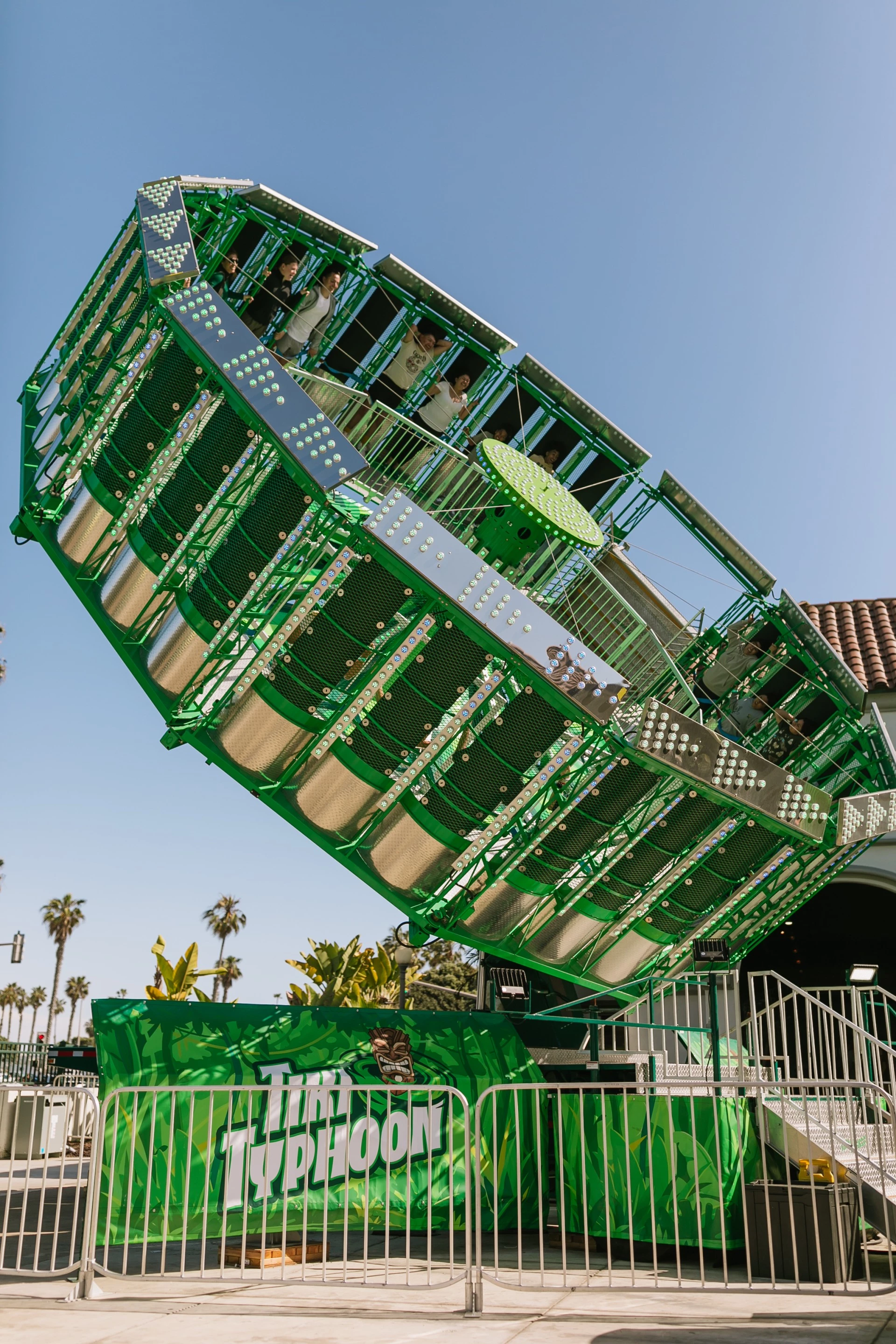 a green ferris wheel with people on it