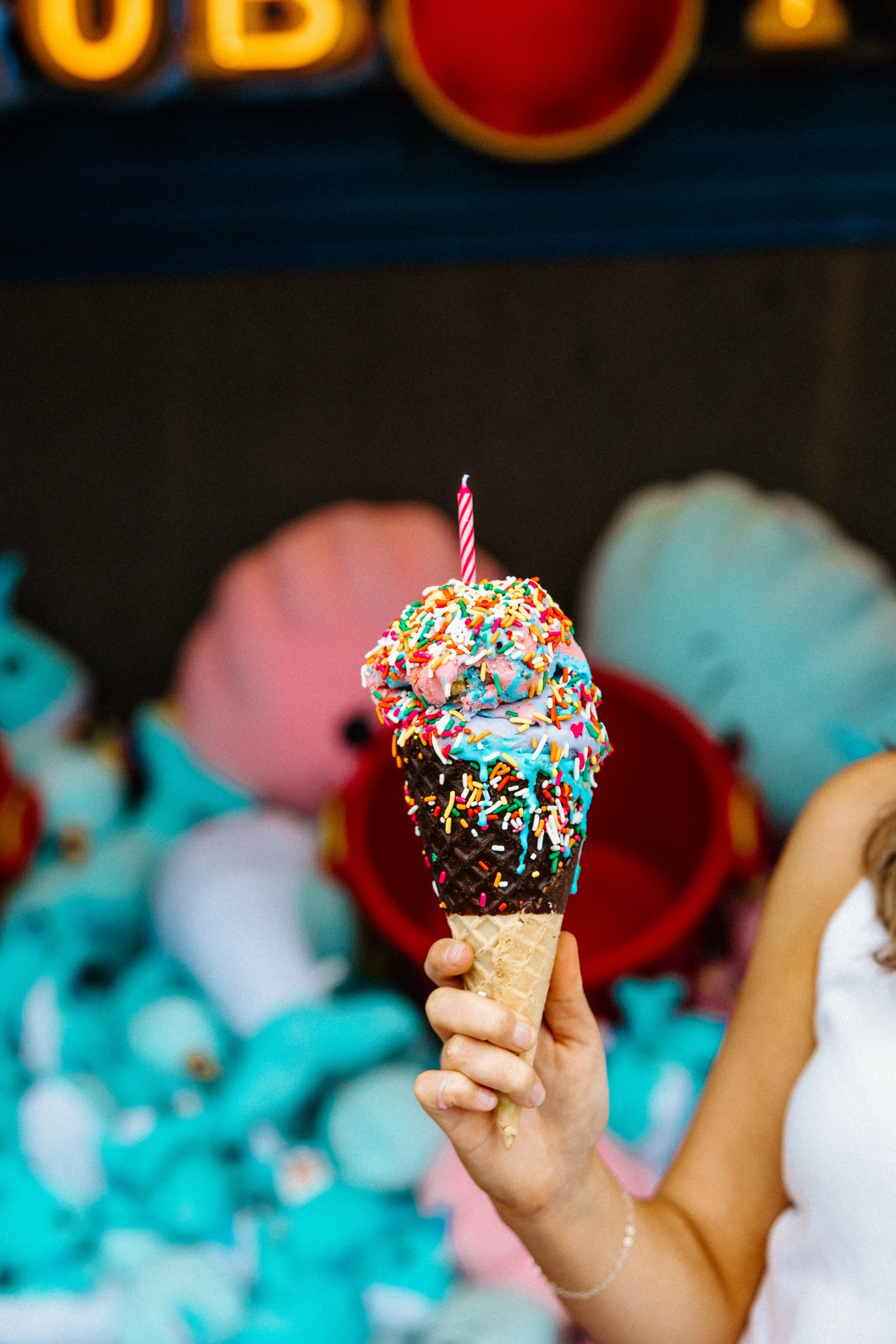a person holding an ice cream cone with a candle