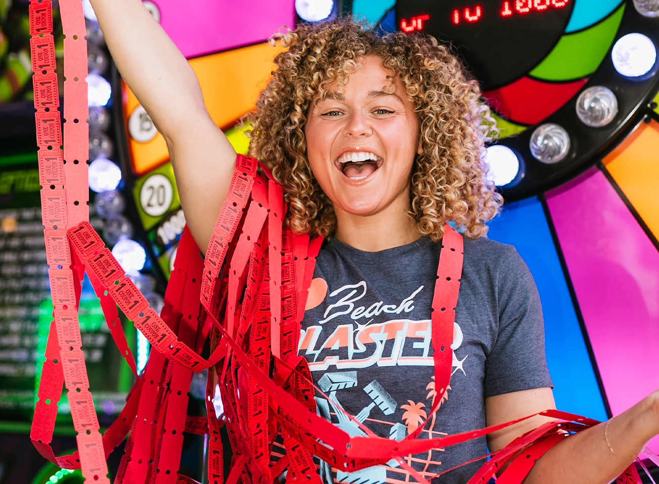 a woman with curly hair holding red ribbons