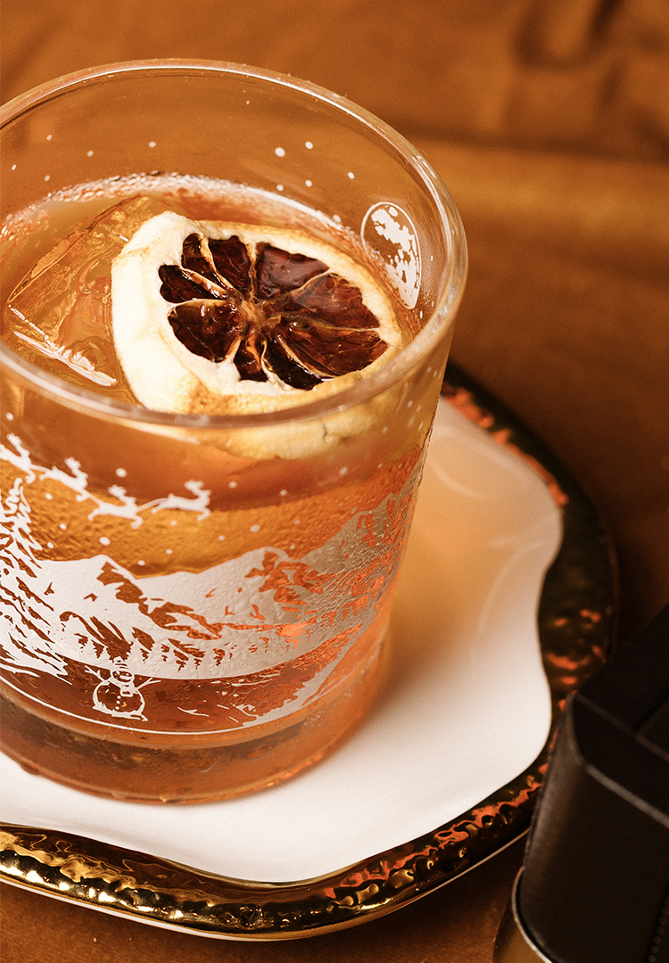 a glass with a drink and a slice of lemon on it
