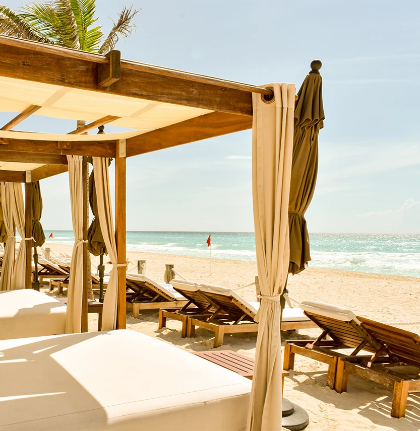 a beach with lounge chairs and umbrellas