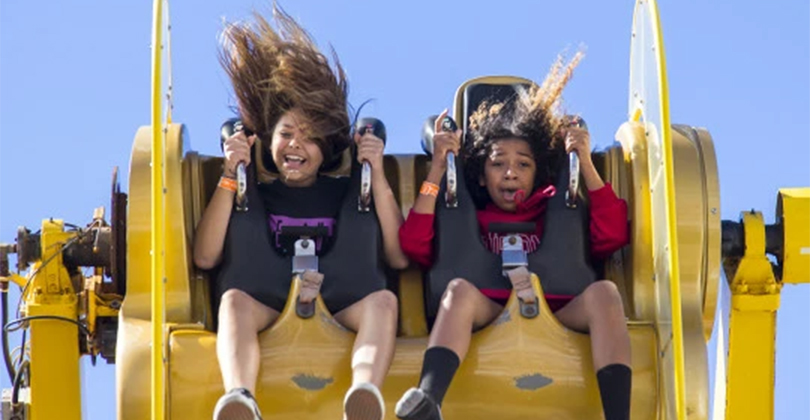 a couple of girls on a roller coaster