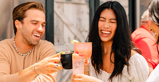 a man and woman holding drinks