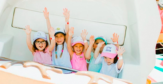 a group of children in hats waving
