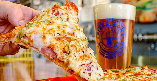 a slice of pizza with a glass of beer