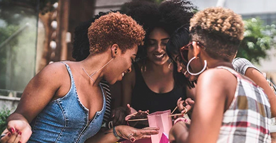 a group of women looking at a small bag
