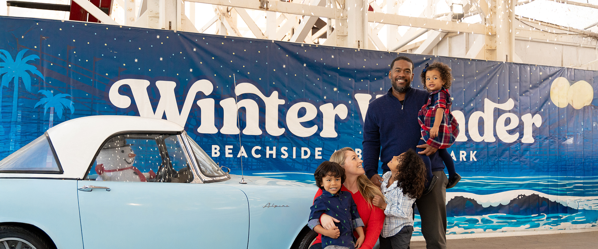 a man and woman with children standing next to a car
