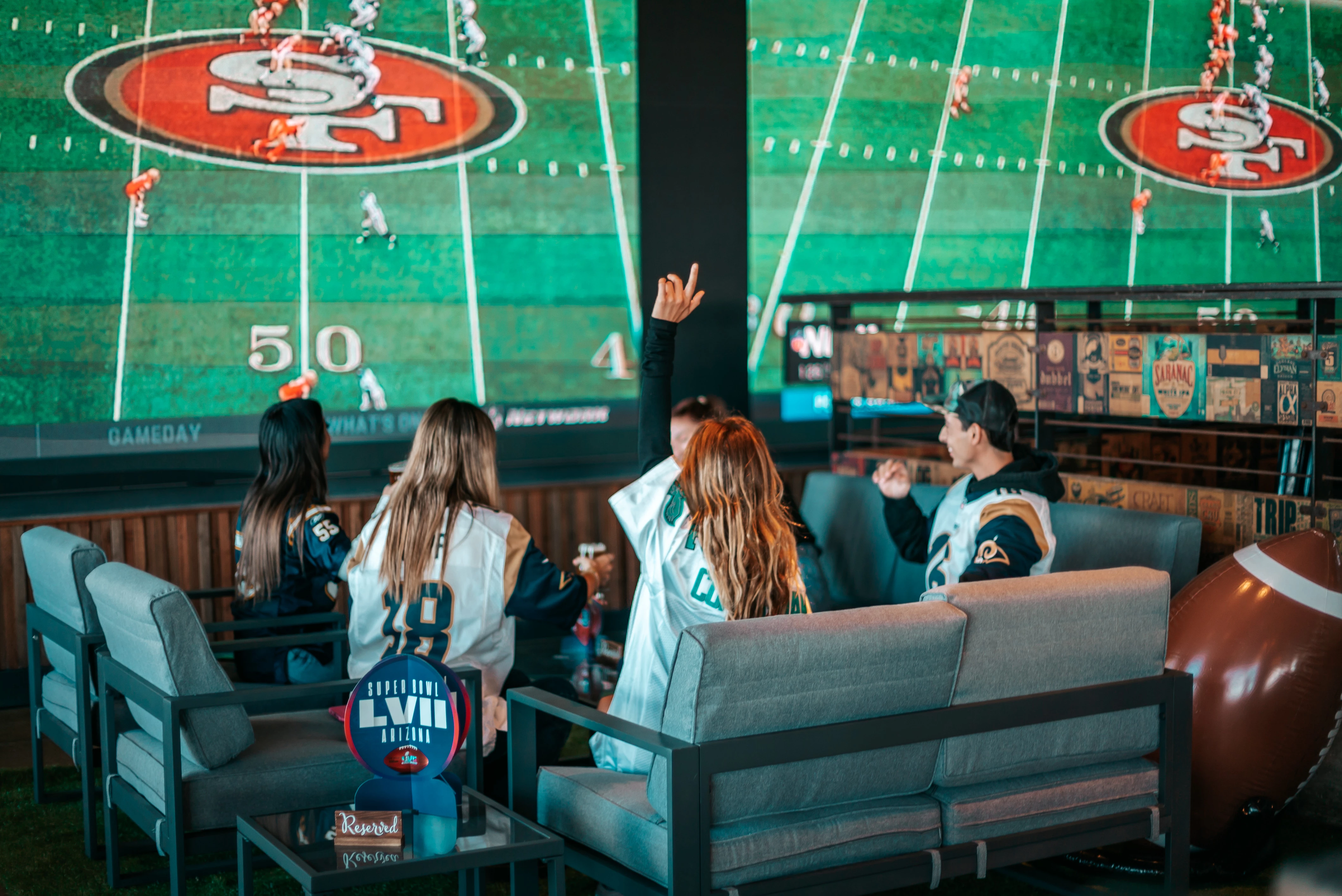 a group of people sitting in a room with a large screen