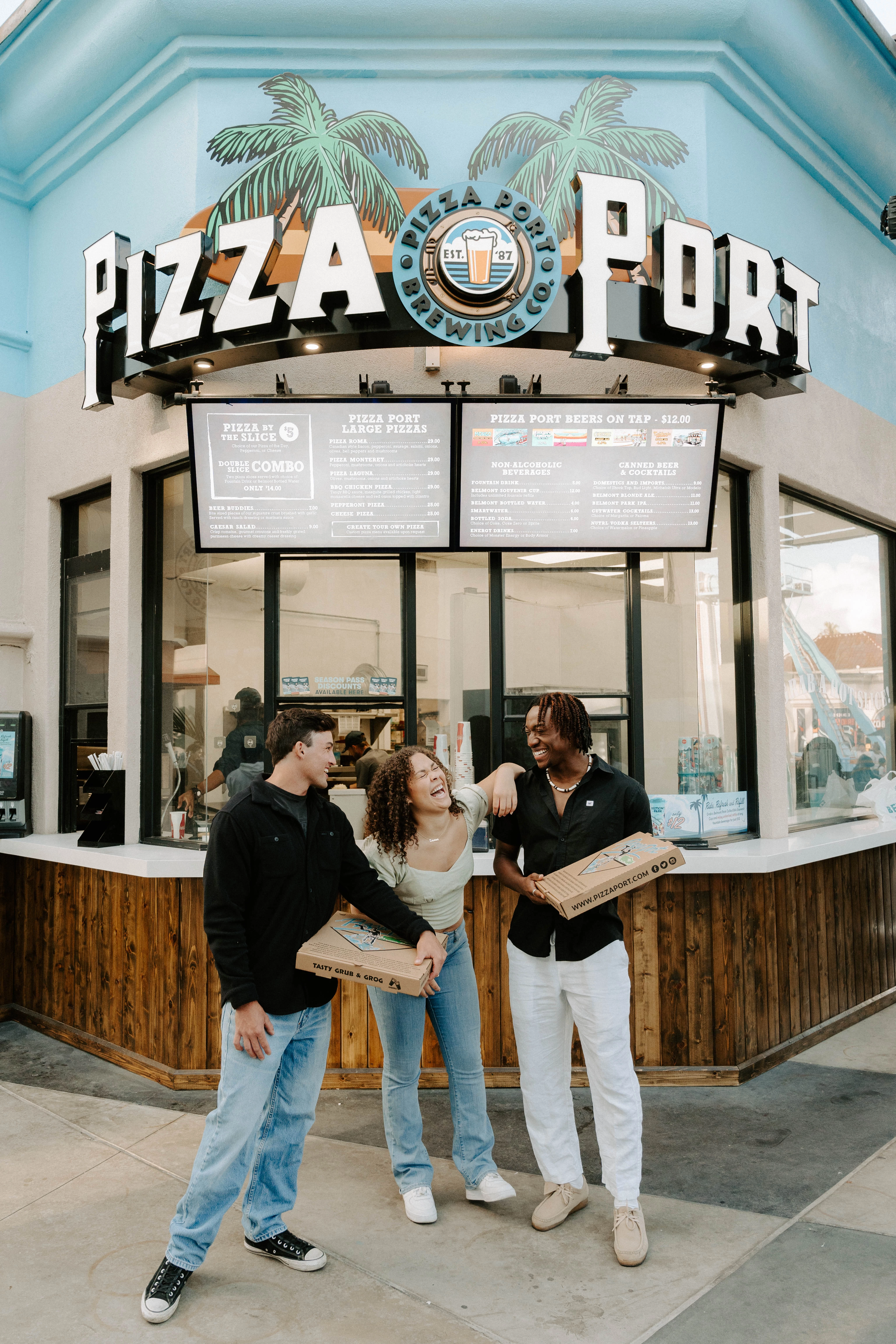a group of people standing in front of a pizza port