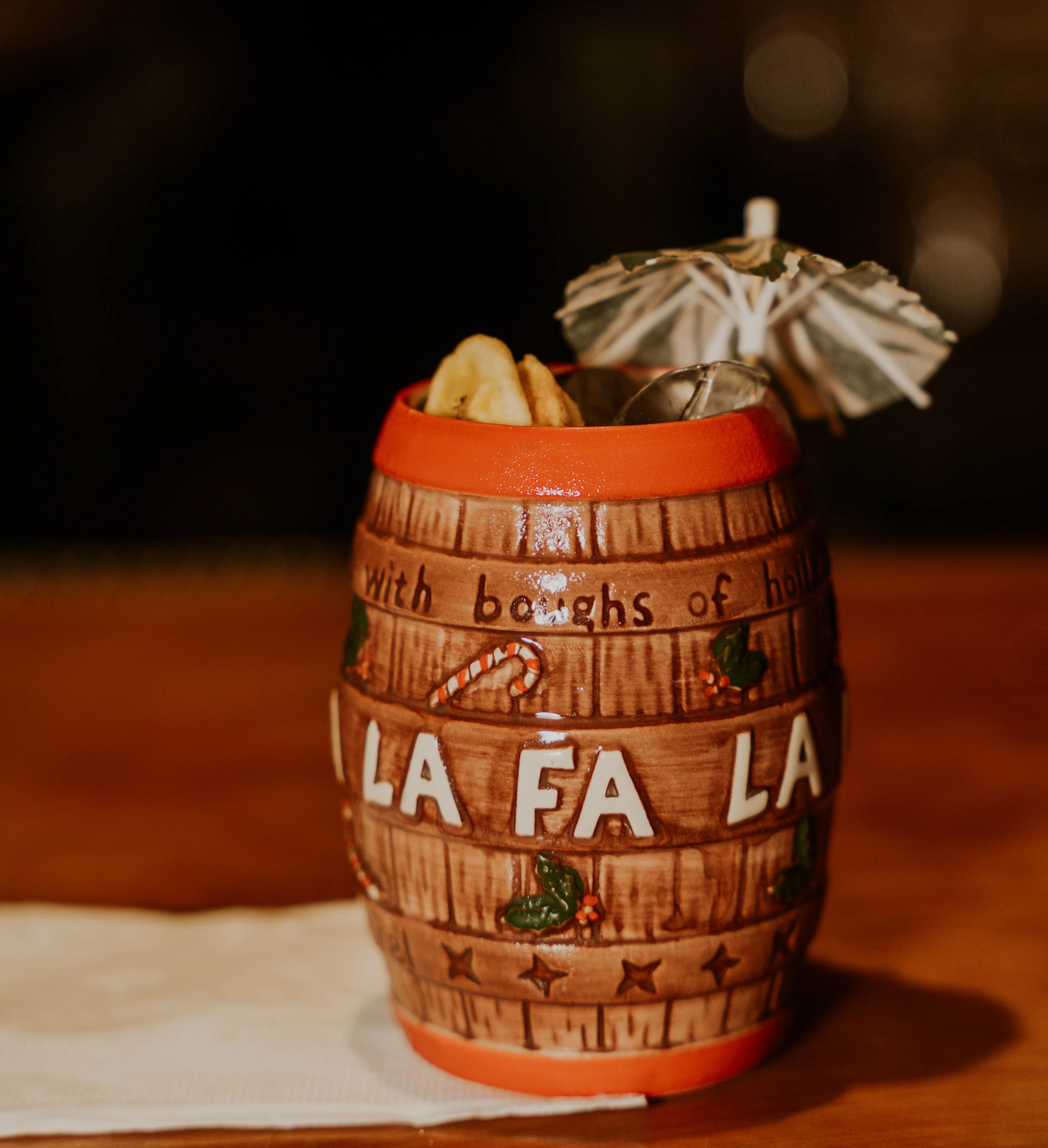 a barrel with a drink and umbrella