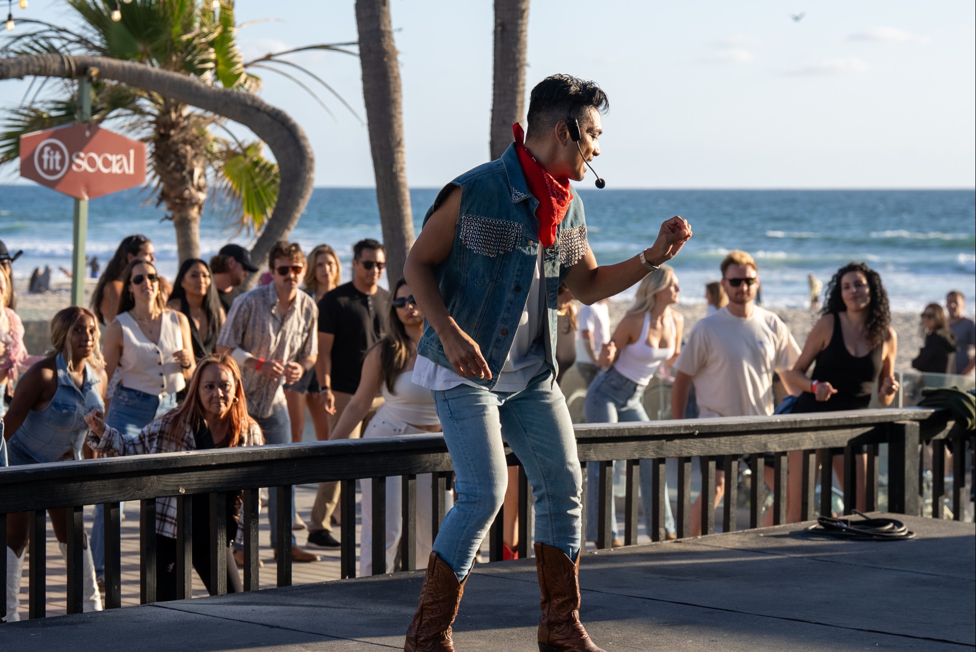 a man wearing a headset and standing on a stage with a crowd of people