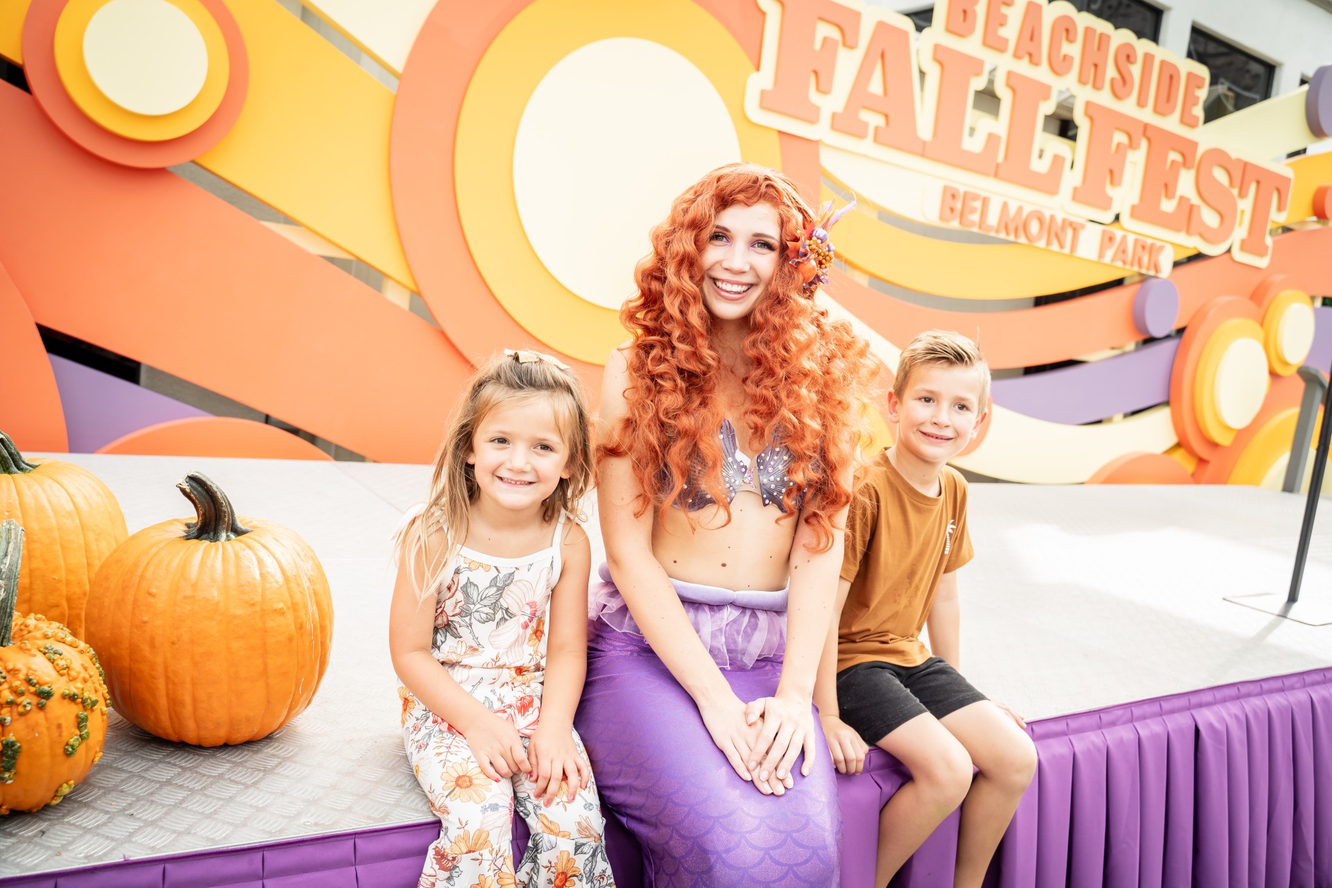 a mermaid and two children posing for a picture