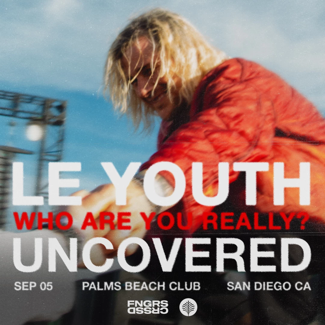 a man with long blonde hair wearing a red coat