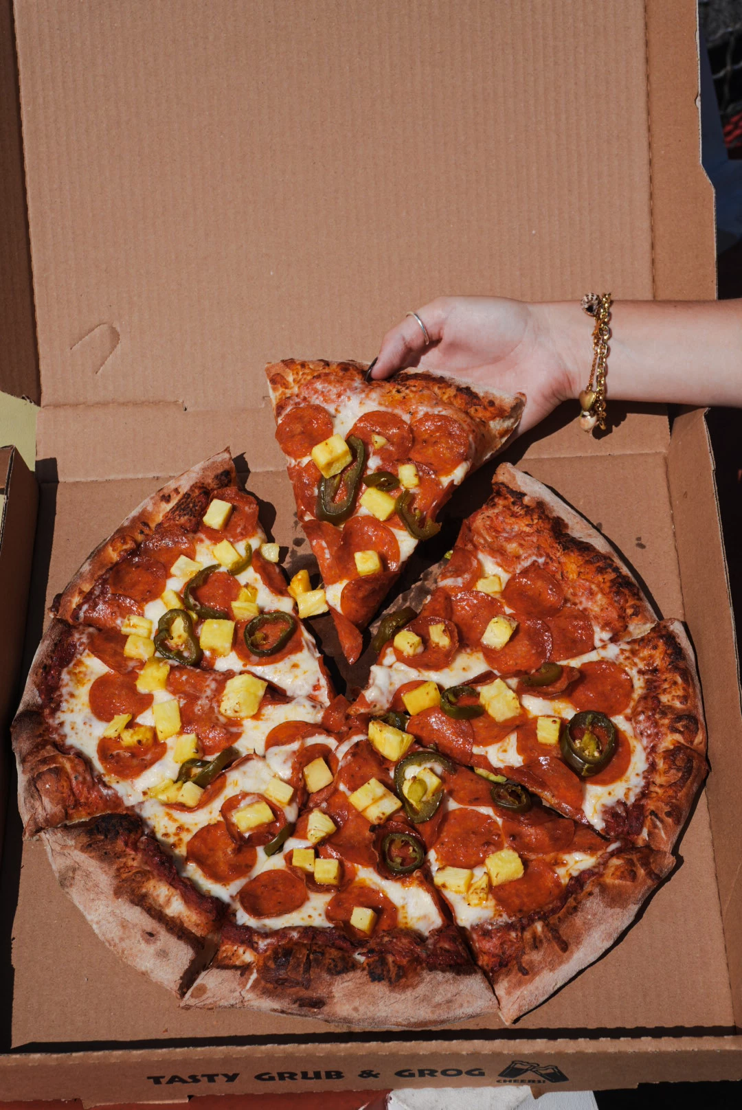 a hand holding a pizza