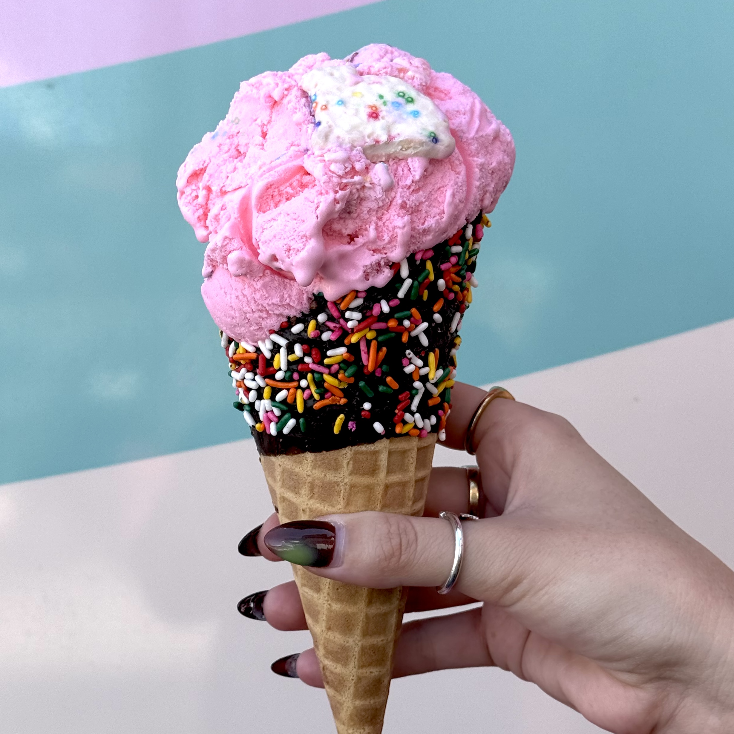 a hand holding an ice cream cone