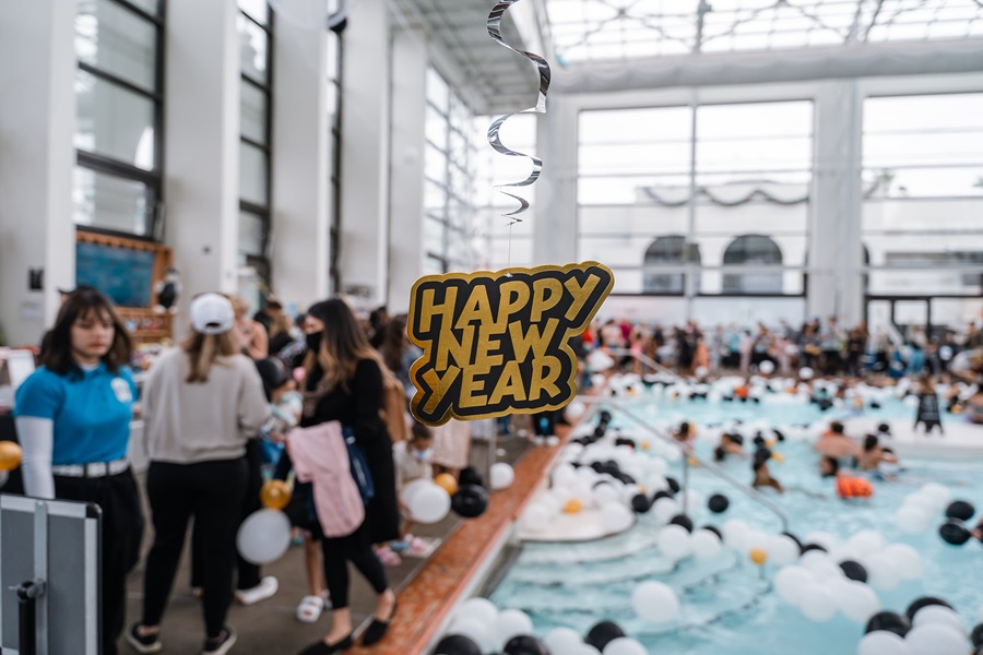 a pool with balloons and a sign from the ceiling