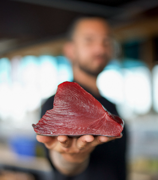 a person holding a piece of meat