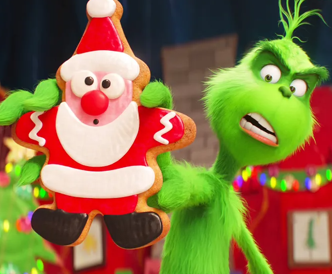 a green character holding a gingerbread cookie