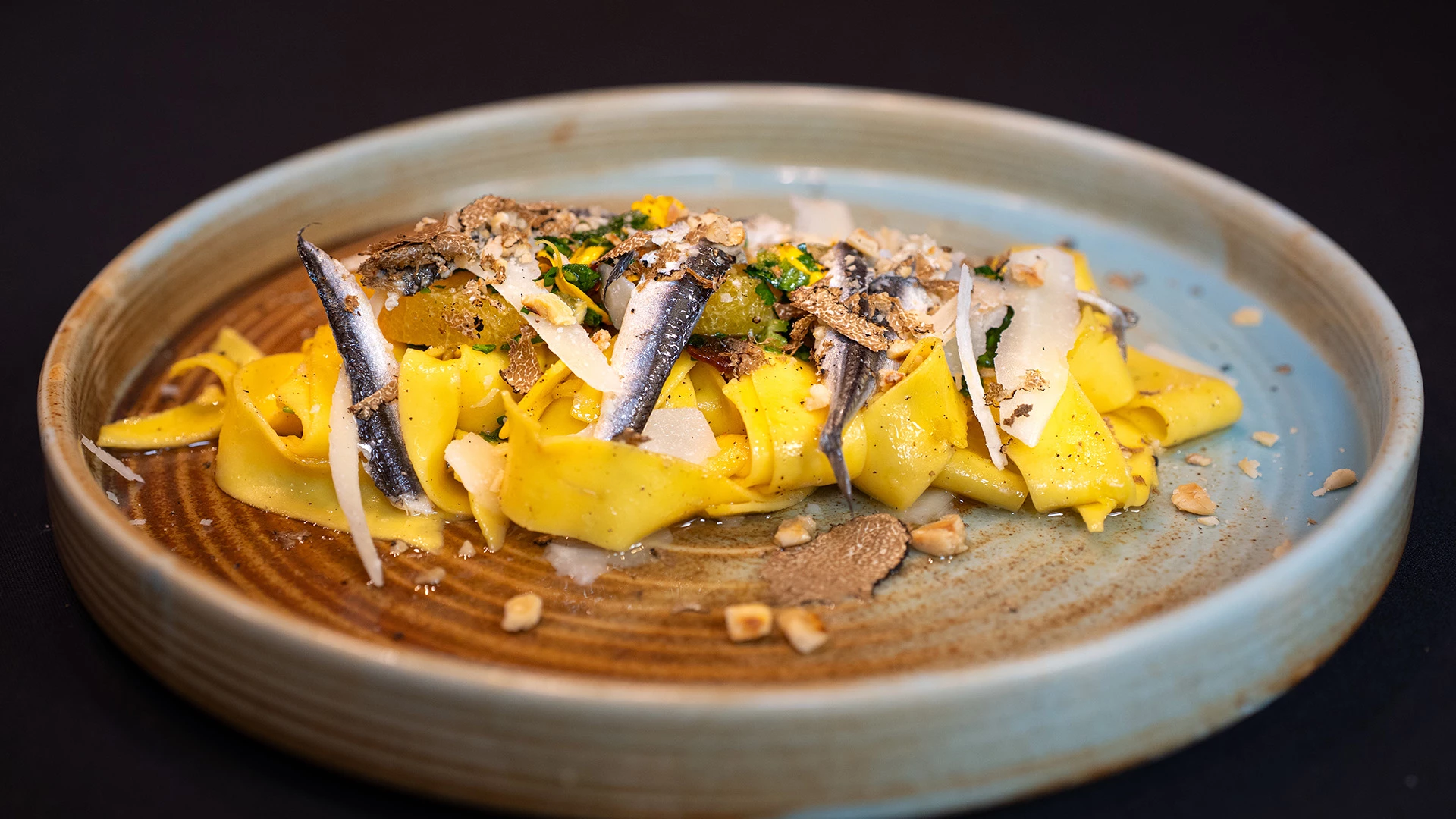 a plate of pasta with anchovies and cheese