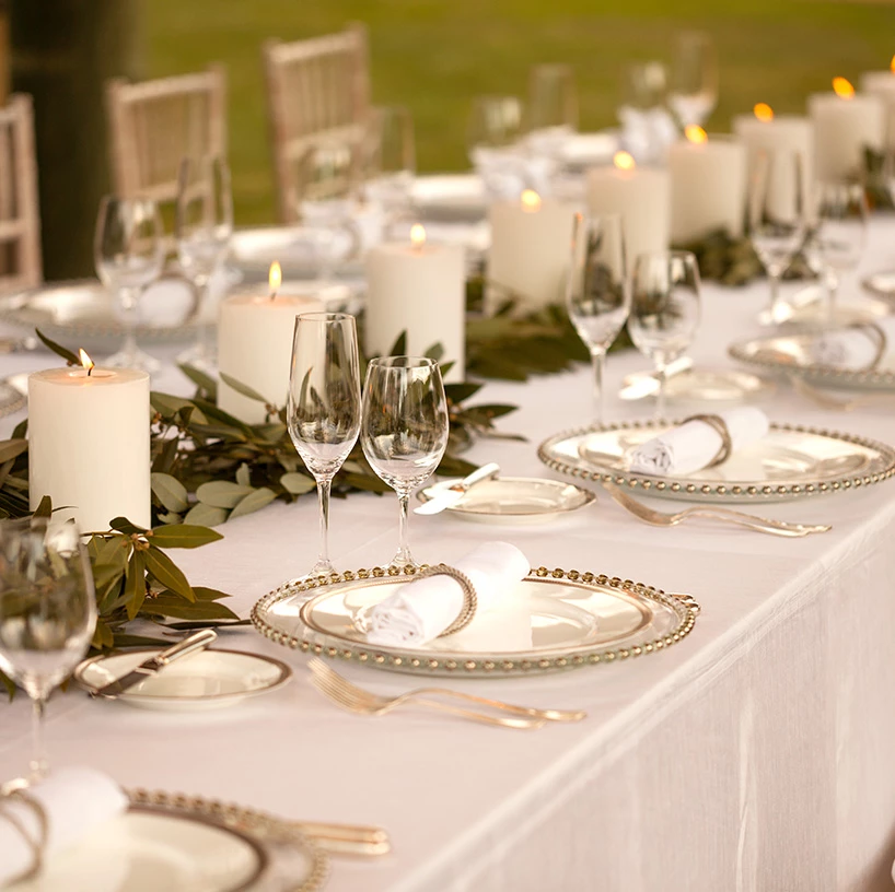 a table with plates and glasses and candles