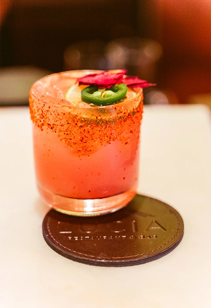 a drink with a jalapeno and a slice of lemon